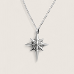 Silver star-shaped pendant on a chain against a light gray background