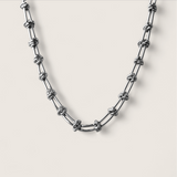 Silver chain necklace on a light gray background