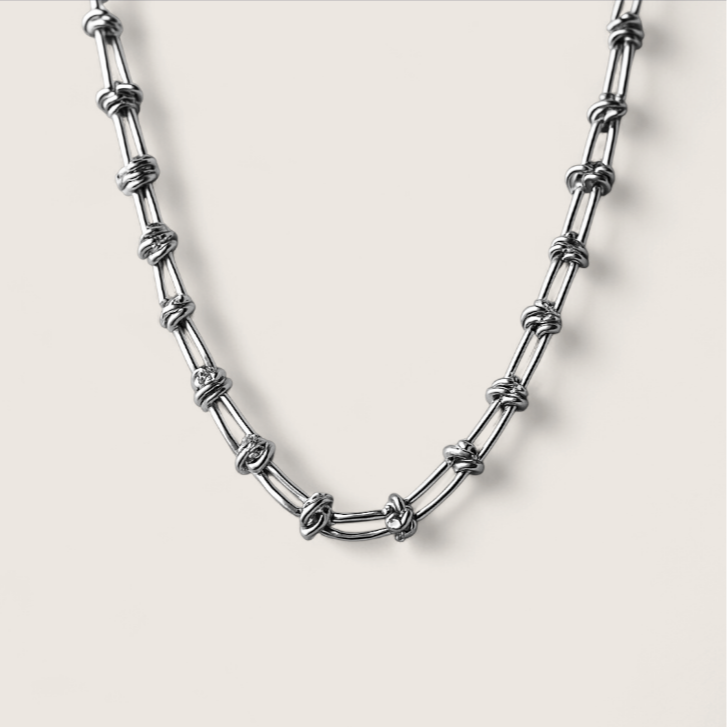 Silver chain necklace on a light gray background