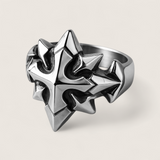 Silver spiked ring on a light gray background