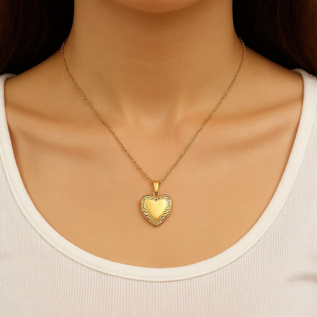Gold heart-shaped necklace on a person wearing a white top